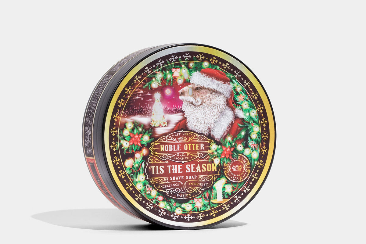 Noble Otter Soap Co. 'Tis the Season shave soap in round tin with Christmas-themed label featuring an otter in a Santa hat