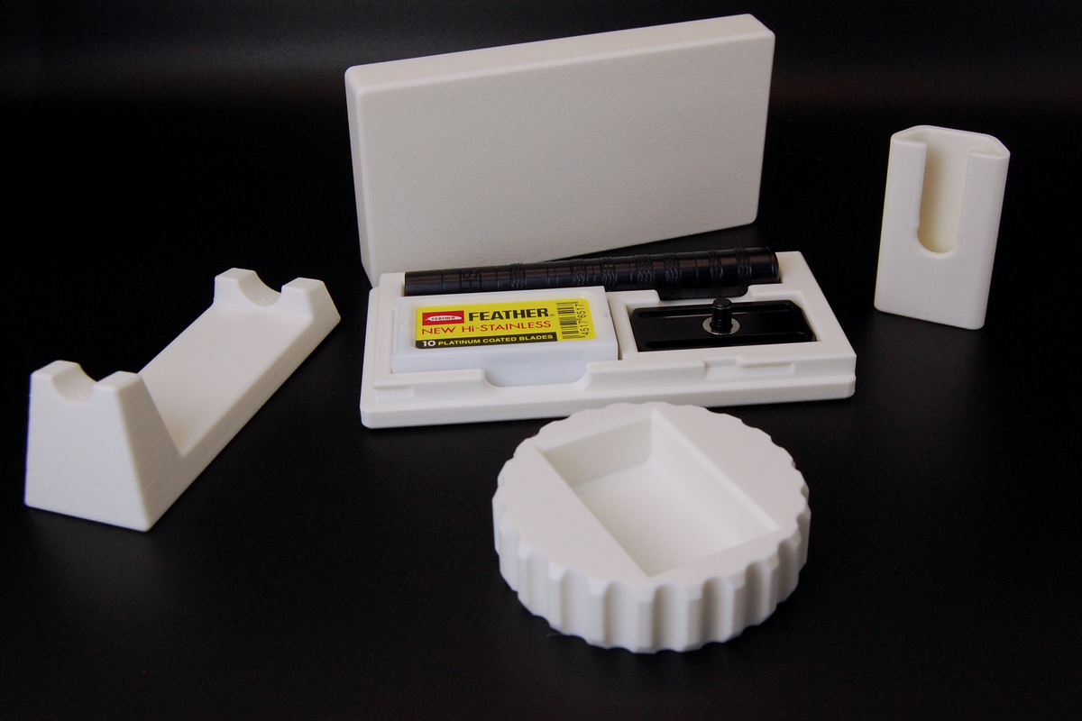 Henson razor bundle in white on black background. Includes Henson Case, Henson Cover, razor stand, razor refueler. Razor not included.