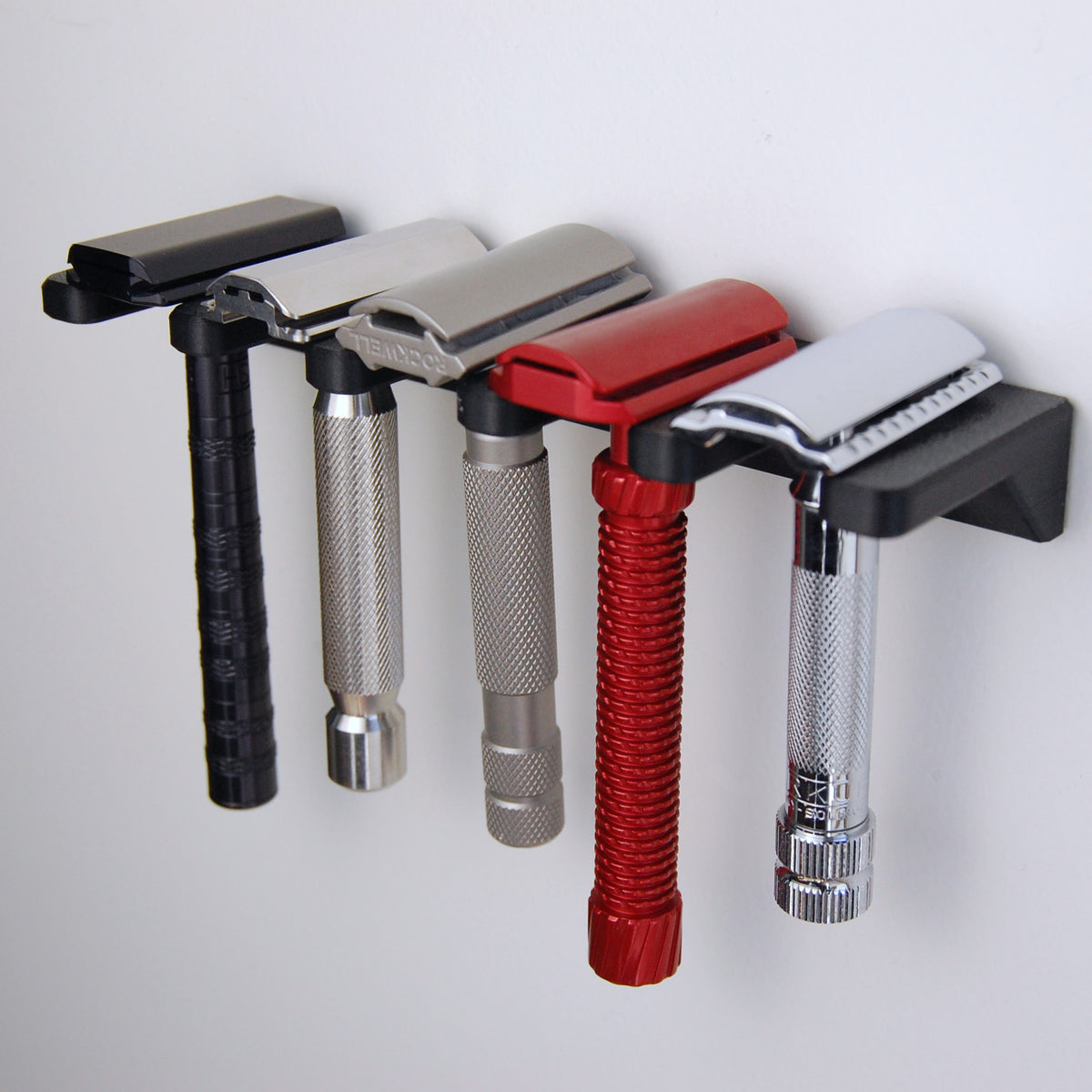 5 slot razor garden wall mount on white wall with 5 razors displayed.