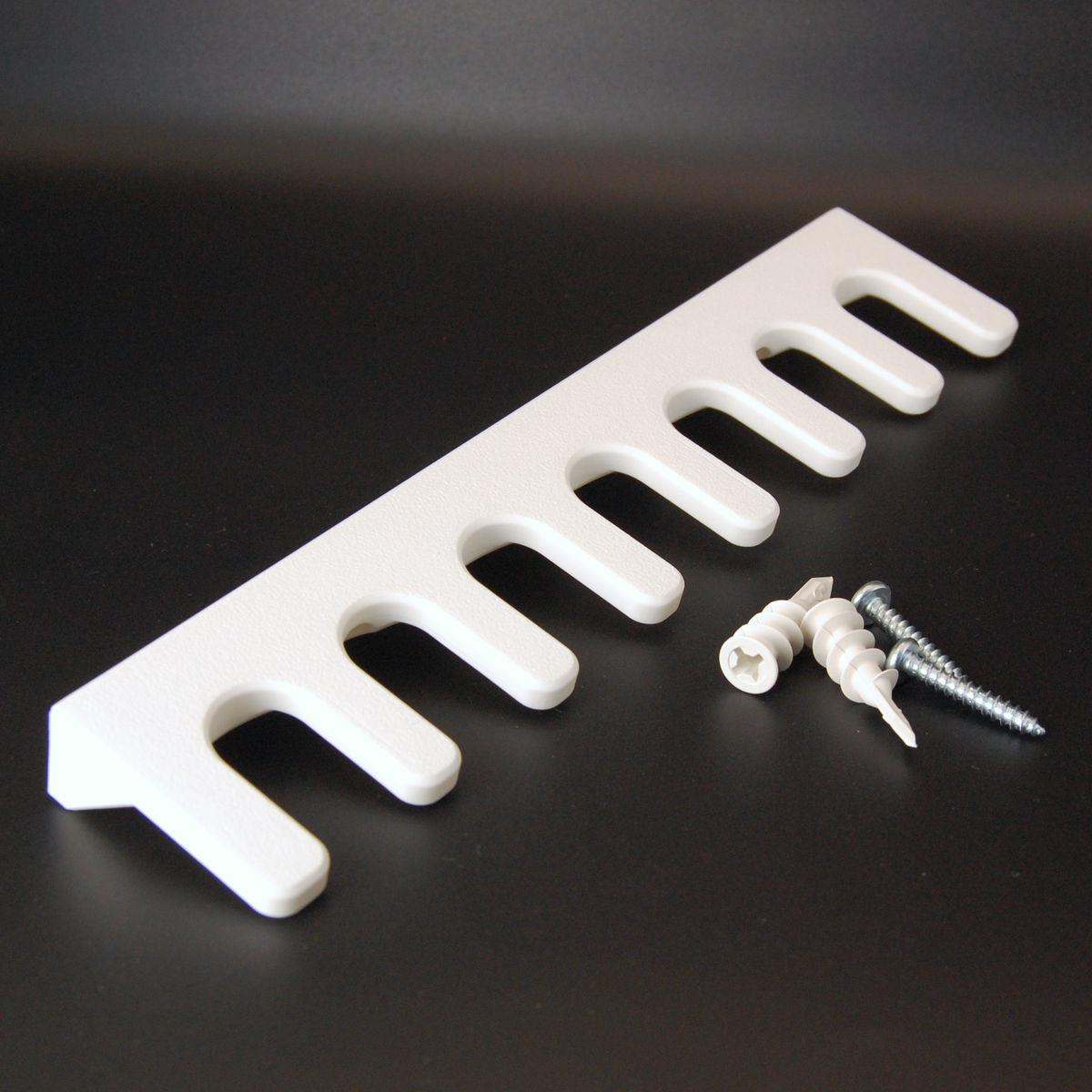 White razor wall mount with mounting kit on a black background.