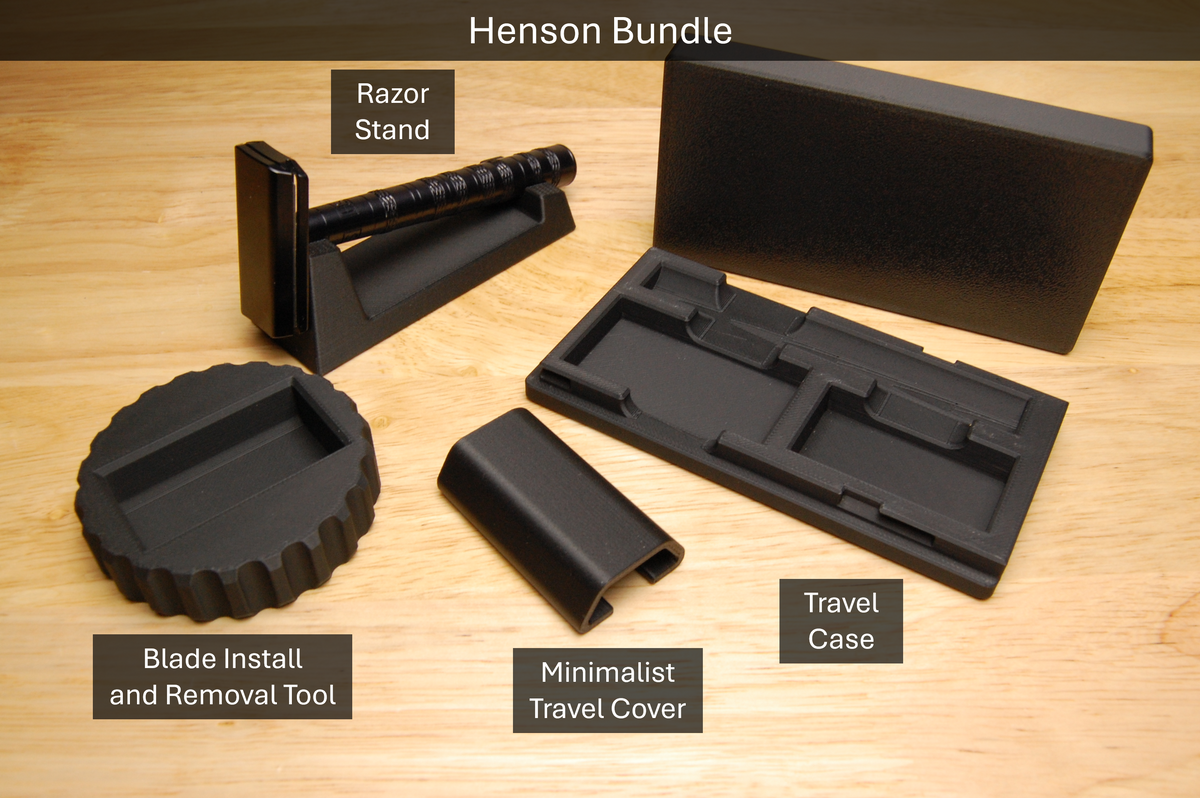 Henson Bundle with Double Edge Razor blade tool, razor stand, minimalist travel cover, and travel case, all in black on a wooden table. Razor not included.