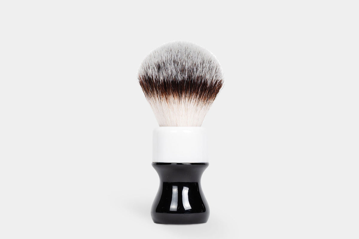 Noble Otter 26mm synthetic shaving brush with black and white two-tone handle and fan-shaped silver-tipped bristles
