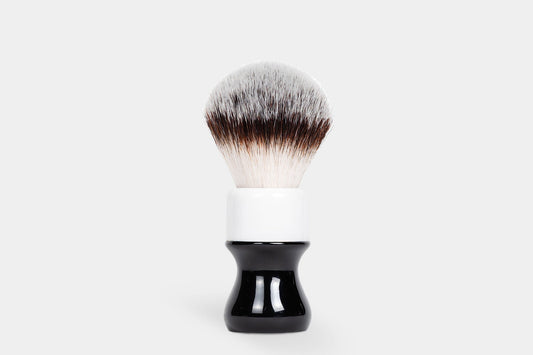 Noble Otter 26mm synthetic shaving brush with black and white two-tone handle and fan-shaped silver-tipped bristles