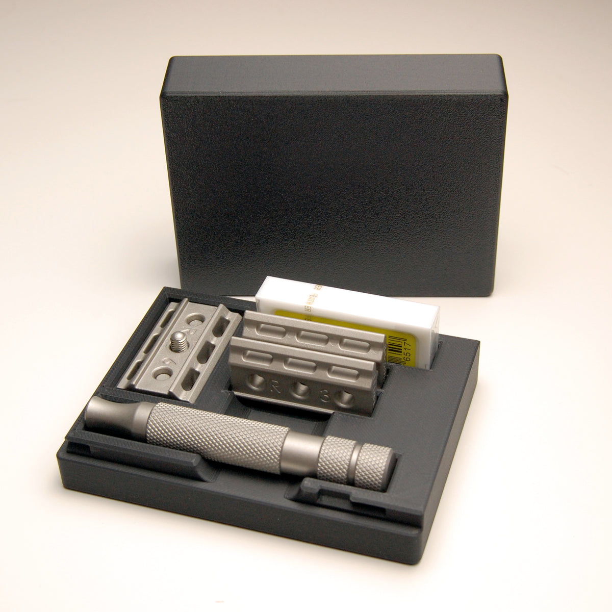 Sophisticated standard black Rockwell 6C/6S razor case on a white background.  The razor and spare blades are in the case.