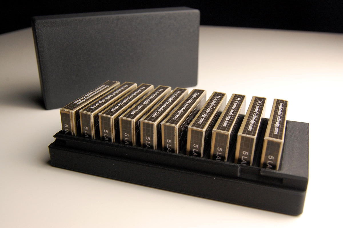 Open black Double Edge Razor Blade storage box on a white table, holding 10 individual razor blade boxes including 10RK blades.
