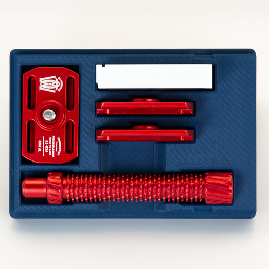 Navy Blue Oliworks M3teorite case open from above: red base plate, top caps, handle and blade box each in its own bay
