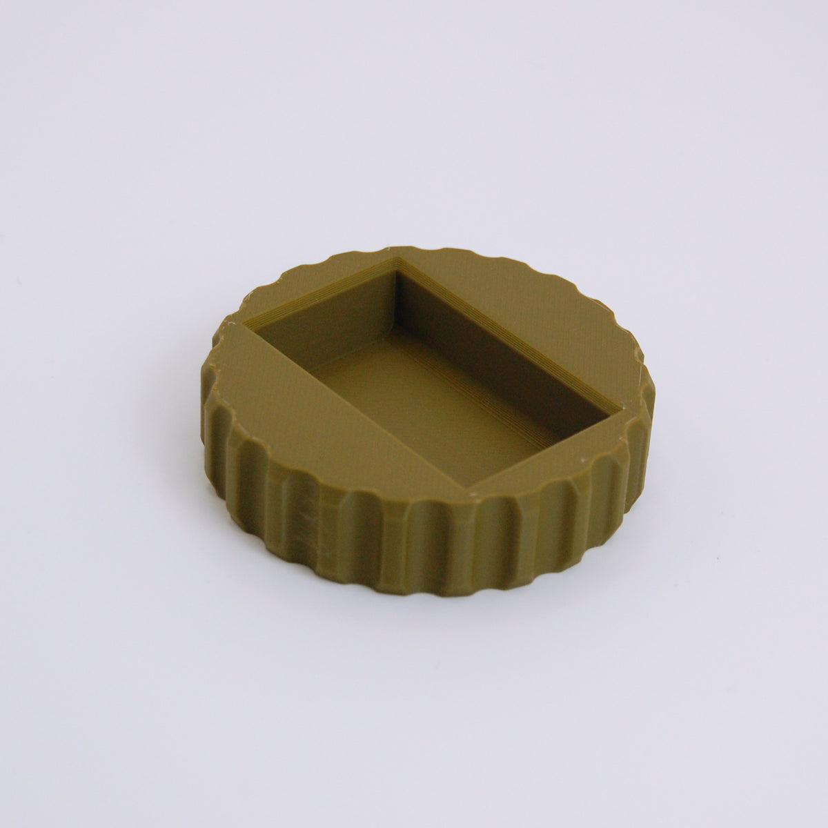 Olive green round razor blade change tool with scalloped grip edge and rectangular slot in center