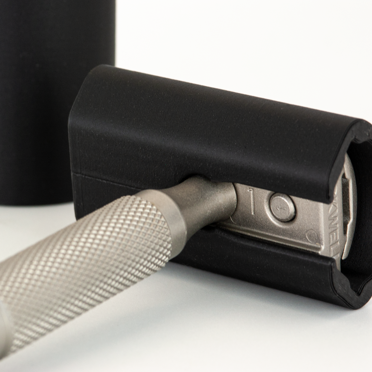 Close-up of a black Rockwell travel cover over a Rockwell 6S head, showing the plate inside and the knurled handle