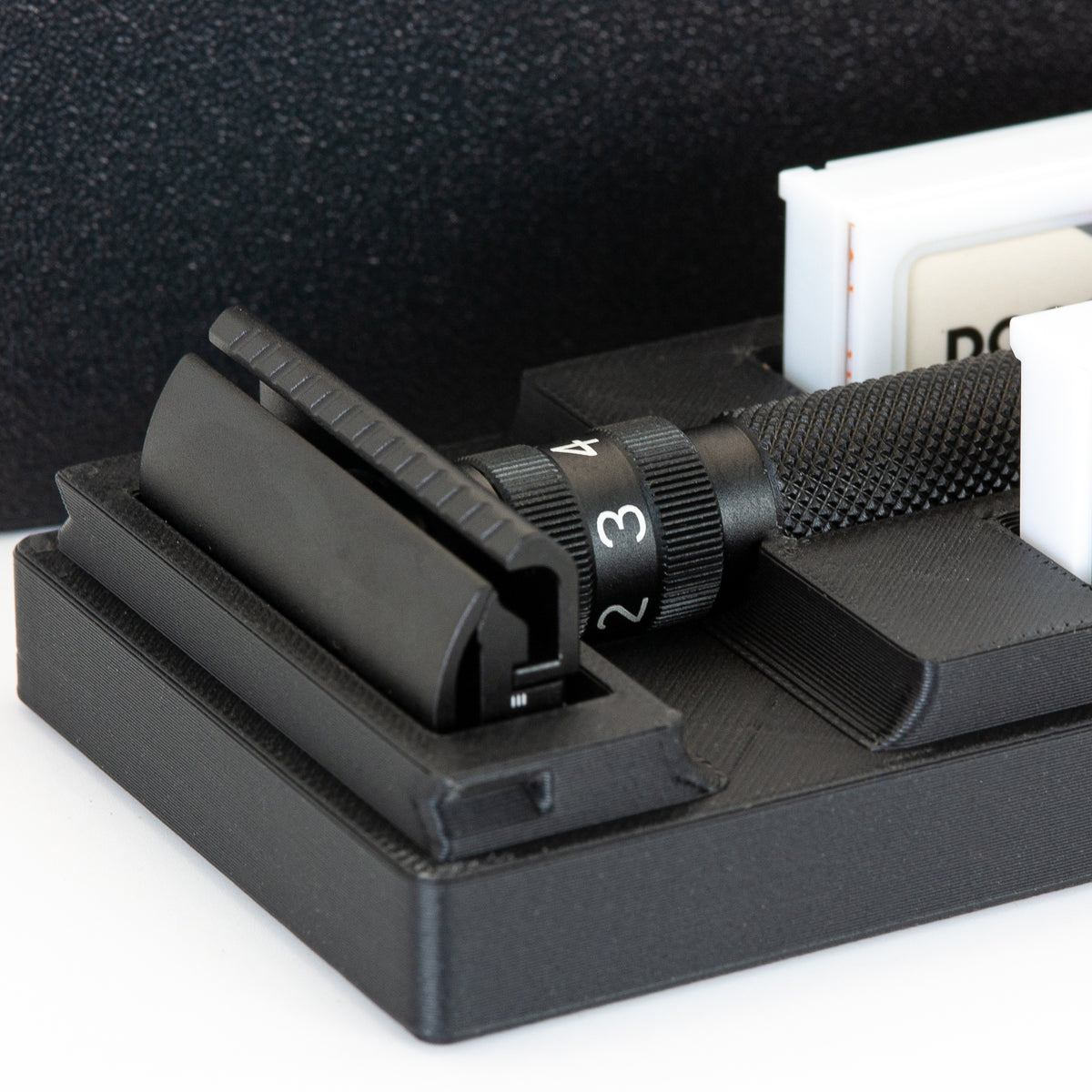 Close-up of the open black Rockwell Setpoint travel case showing the razor head in its bay and the adjustment dial on the handle