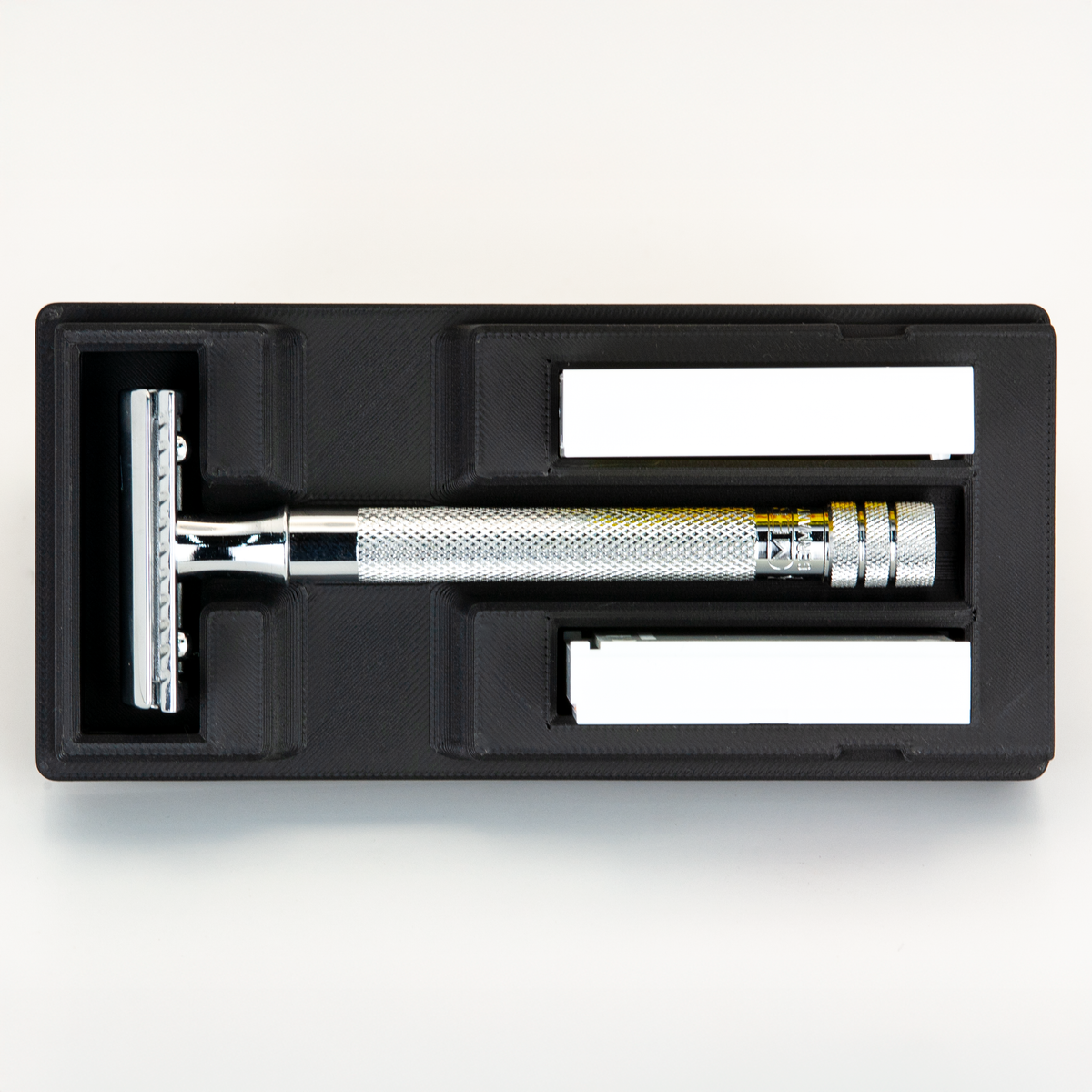 Black Universal Razor Travel Case from above with a chrome Merkur 34C seated in it and two blade boxes alongside