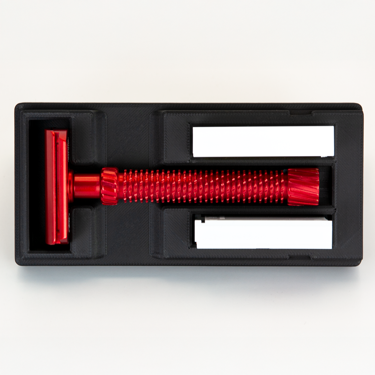 Black Universal Razor Travel Case from above with a red Oliworks M3teorite seated in it and two blade boxes alongside