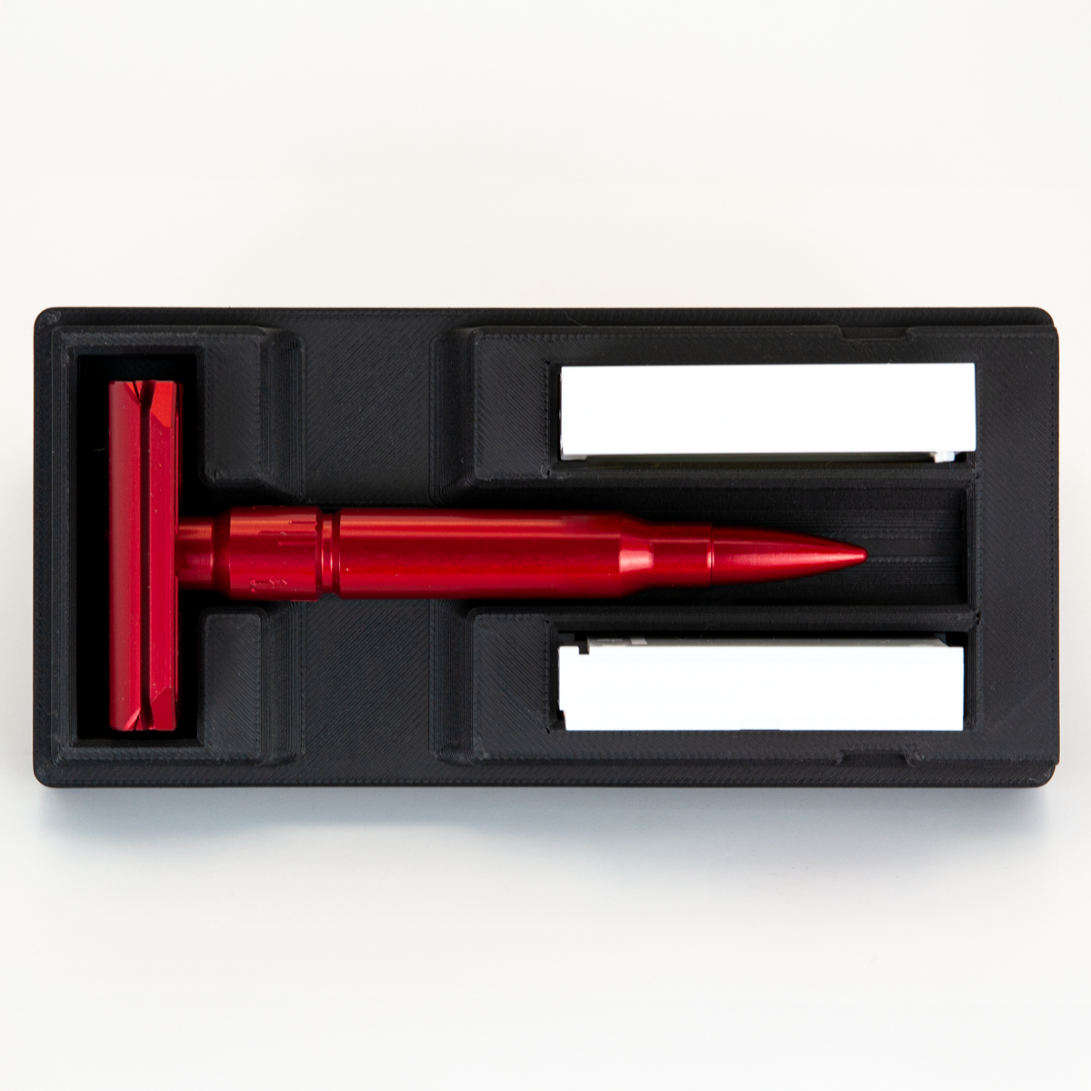 Black Universal Razor Travel Case from above with a red Tier One Echelon on its .308 bullet handle and two blade boxes alongside